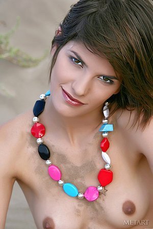 Brunette with a confident look shows her firm ass and more in the sand