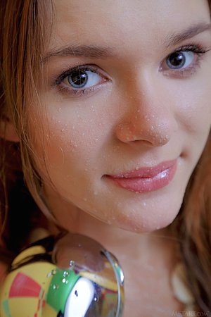 Blond-haired playful chick posing on all fours on the bathroom floor