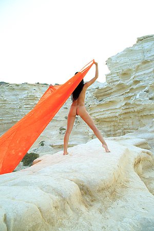Tanned brunette with a hairy pussy chillaxing on a really rocky beach