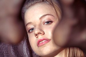 Babe in hat posing in her sexy black stockings on a grey couch