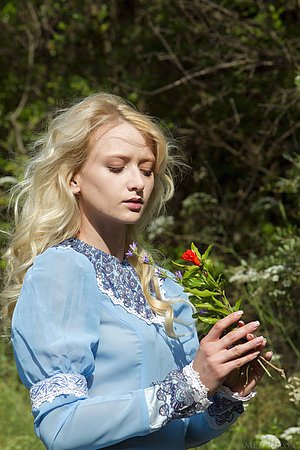 Graceful blonde in ancient clothes shows her pussy on the grass