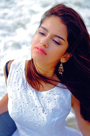 Stockings-clad brown-eyed Latina shows off her perfect body on a bed