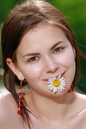 Denim shorts brunette shows her perfect body in the middle of a field