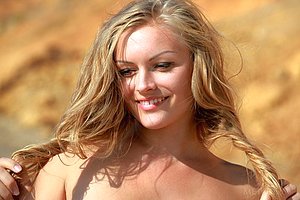 Flexible nudist doing yoga moves and cartwheels while naked on a beach