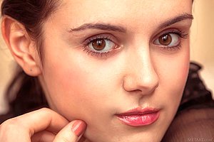 Ponytailed brunette in a bodysuit hiding her pussy with a fedora