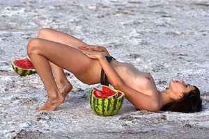 Watermelon-loving brunette posing completely naked on a secluded beach