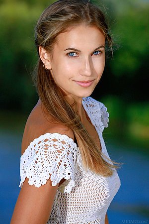 Denim shorts wearing blue-eyed brunette goddess poses next to a lake
