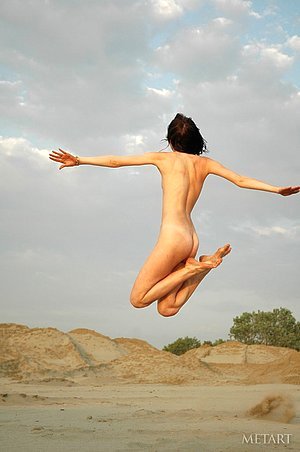 Flexible and athletic brunette posing totally nude in the dunes
