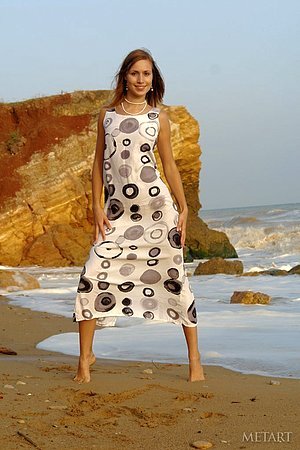 Dark-haired beauty with long legs posing on the beach and looking hot