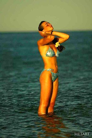 Bikini-wearing teenage nudist goes topless while enjoying the water